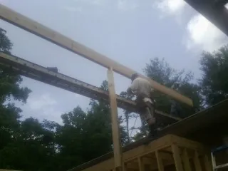 Carpenter setting a ridge beam over a new addition frame — Ice Dam Removal by Roofing Brothers in Bat Cave