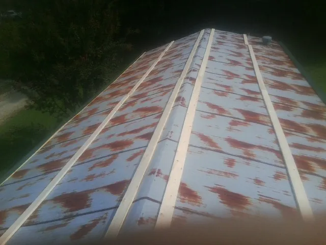 Rusted metal roof panels with new wood purlins before replacement — Storm Damage Roof Repair in Bat Cave by Roofing Brothers