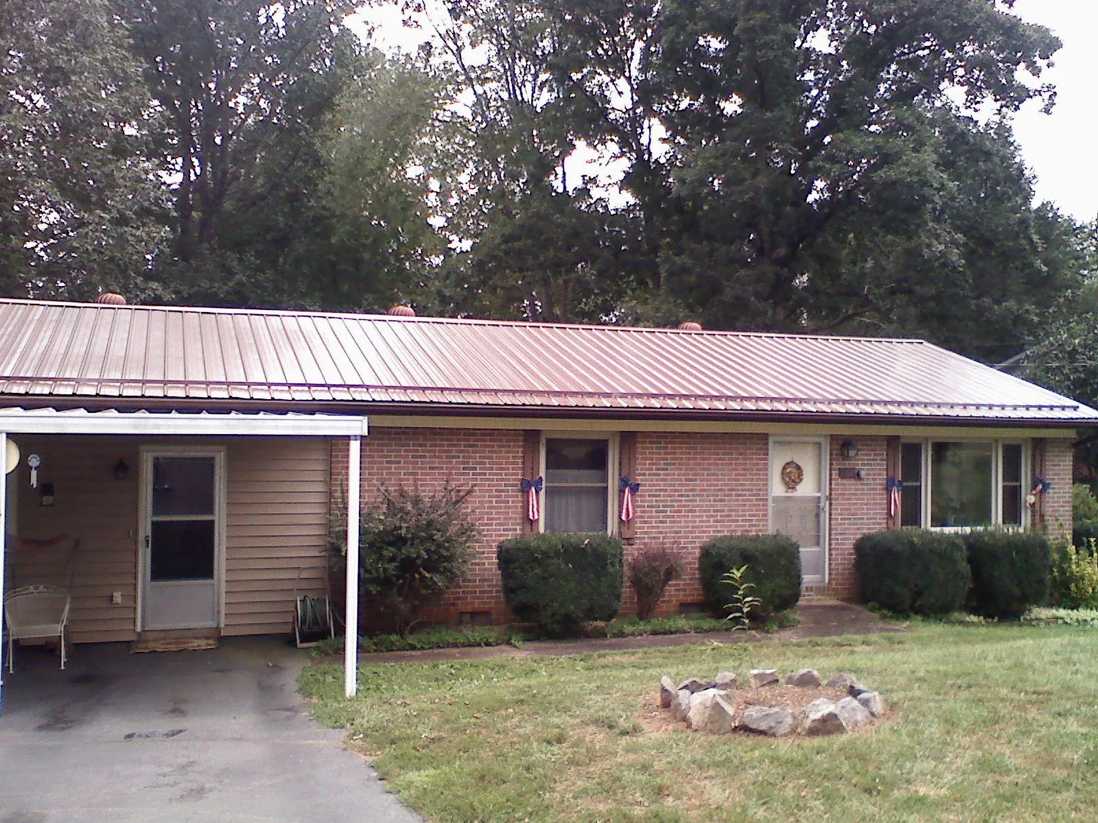 Bronze metal roof and carport on a brick ranch home — Roof Repair work by our crew in Bat Cave